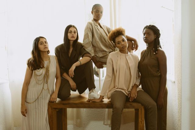 Five diverse women in fashionable outfits representing empowerment and unity.